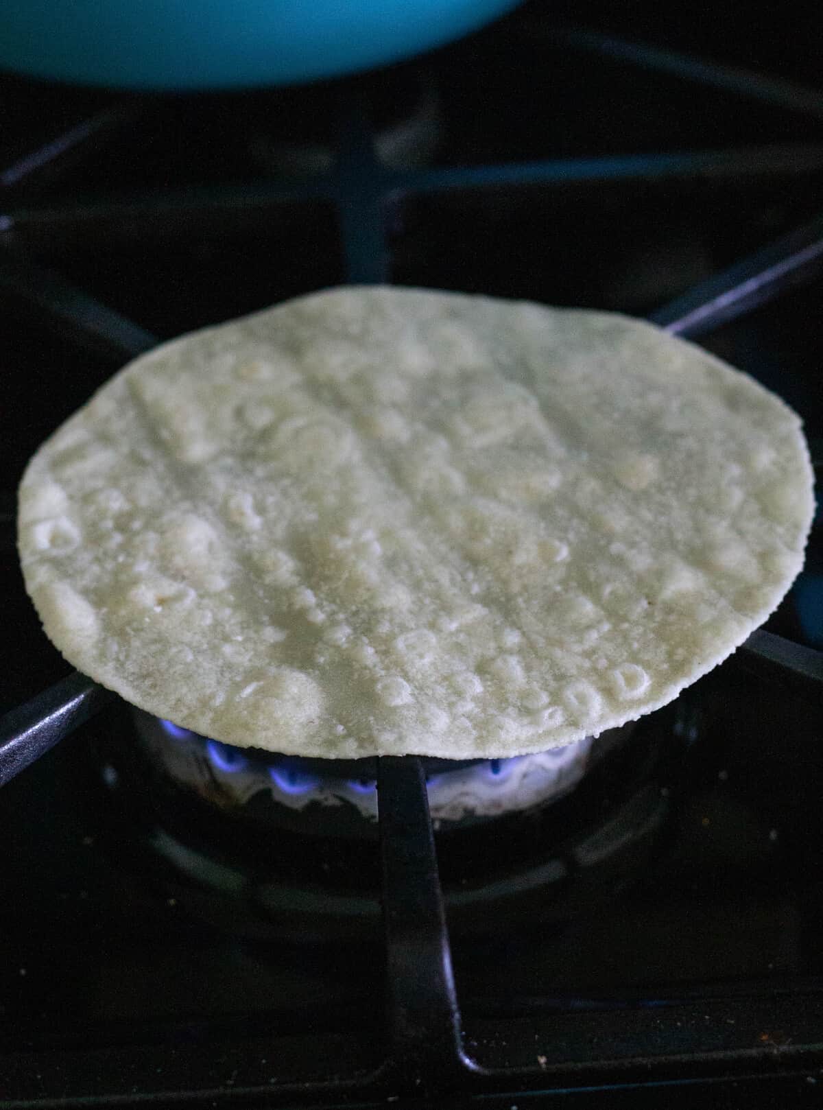 tortilla being heated on gas stove