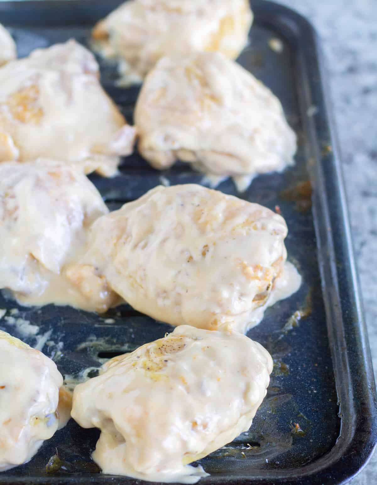 chicken dipped in glaze on pan.