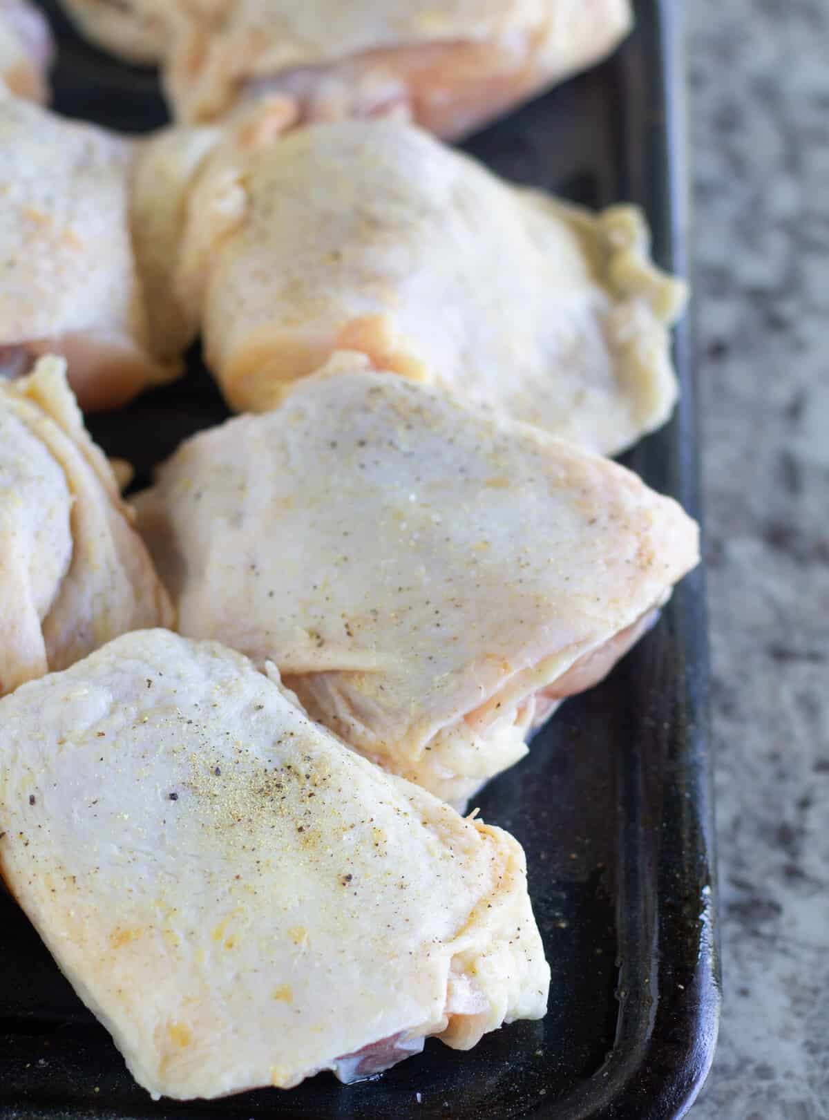 uncooked hicken thighs on broiler pan