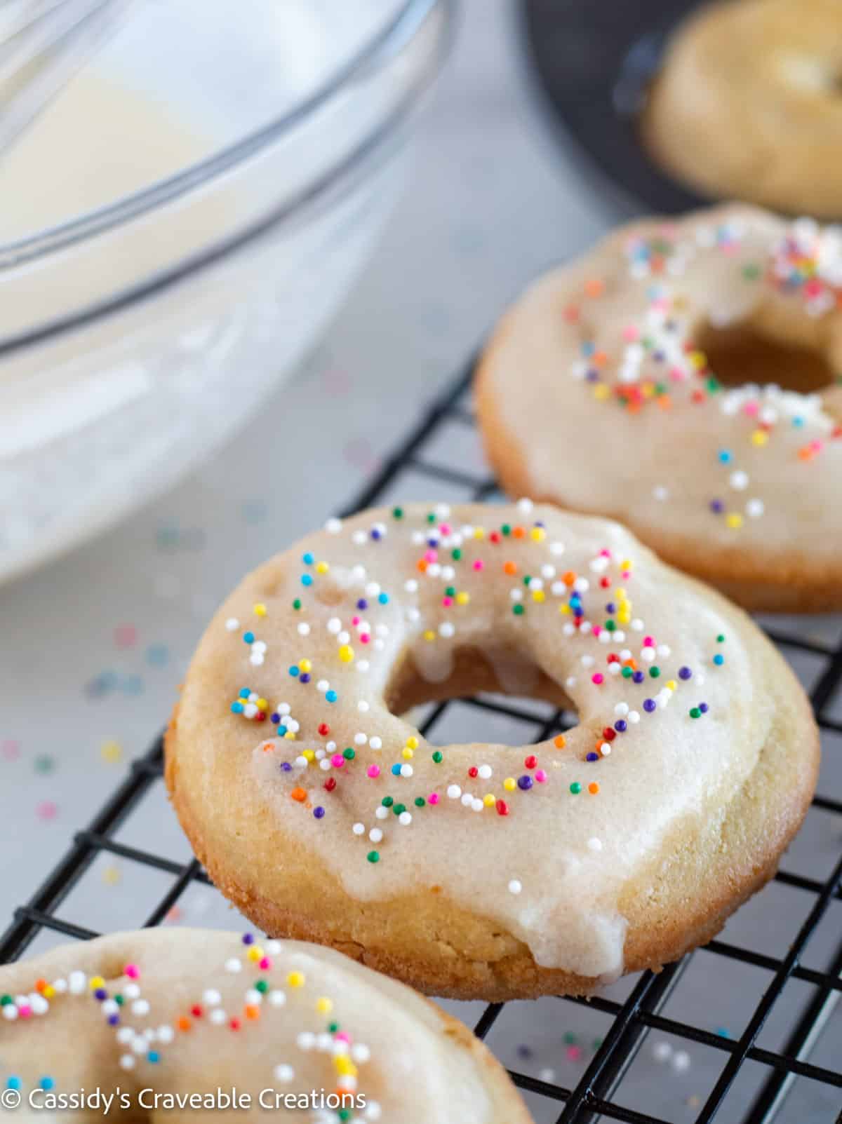 close up of glazed donut with sprinkles
