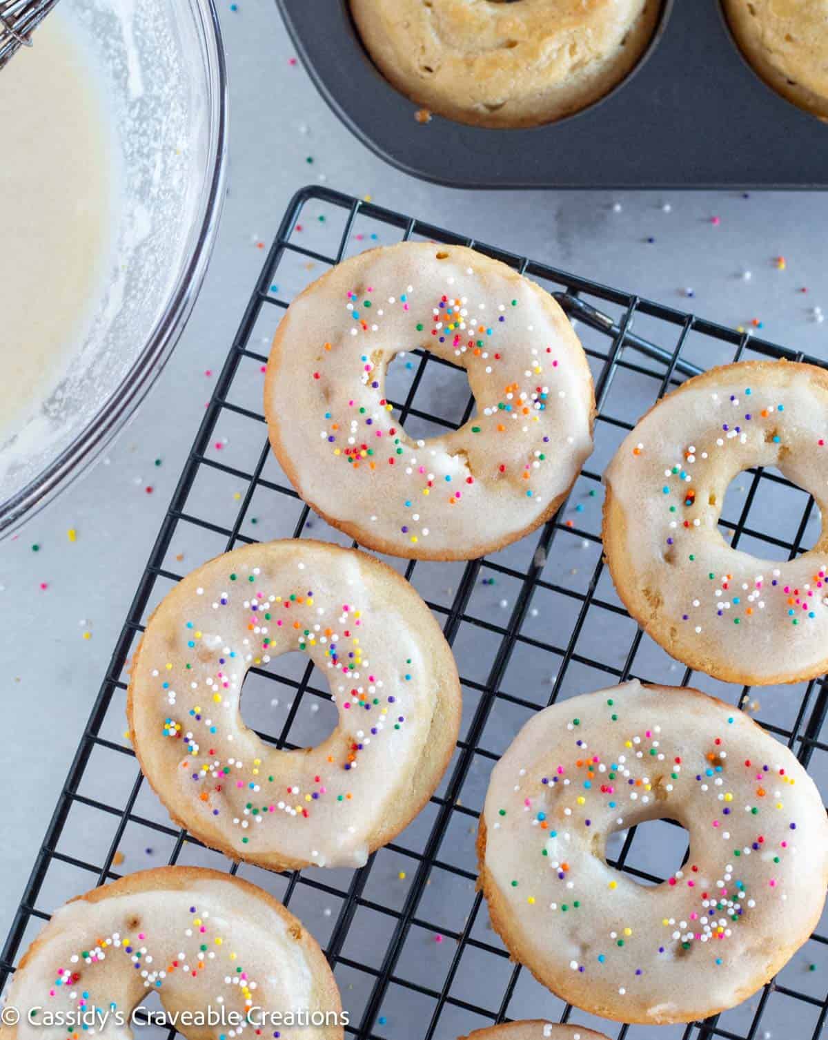 donuts on cooling rack with glaze and sprinkles