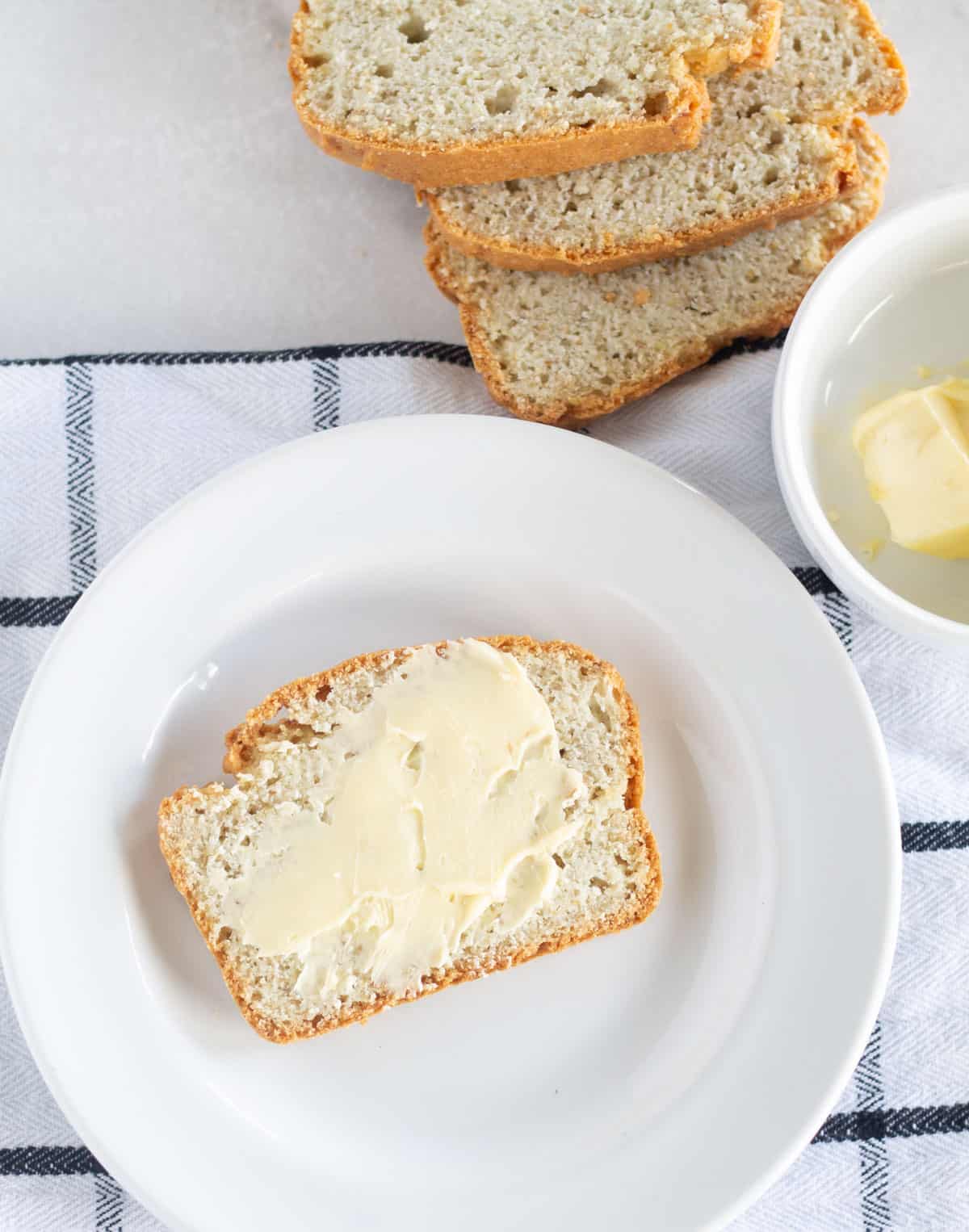 slice of keto bread withe butter on white plate