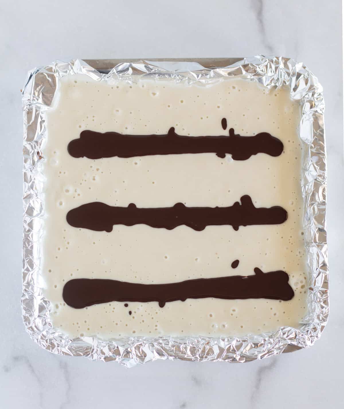 3 lines of chocolate drizzled on top of the cheesecake.