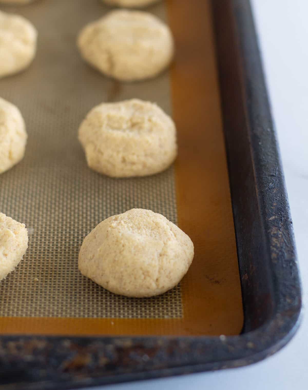 unbaked cookies on lined baking sheet.