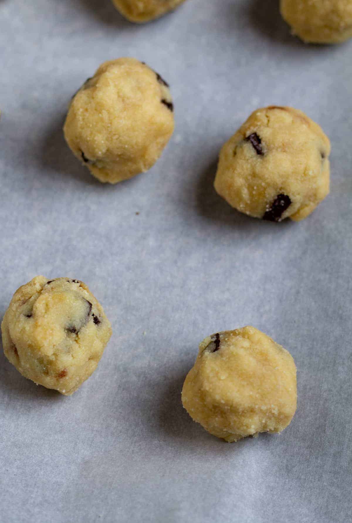 dough rolled into balls on parchment paper