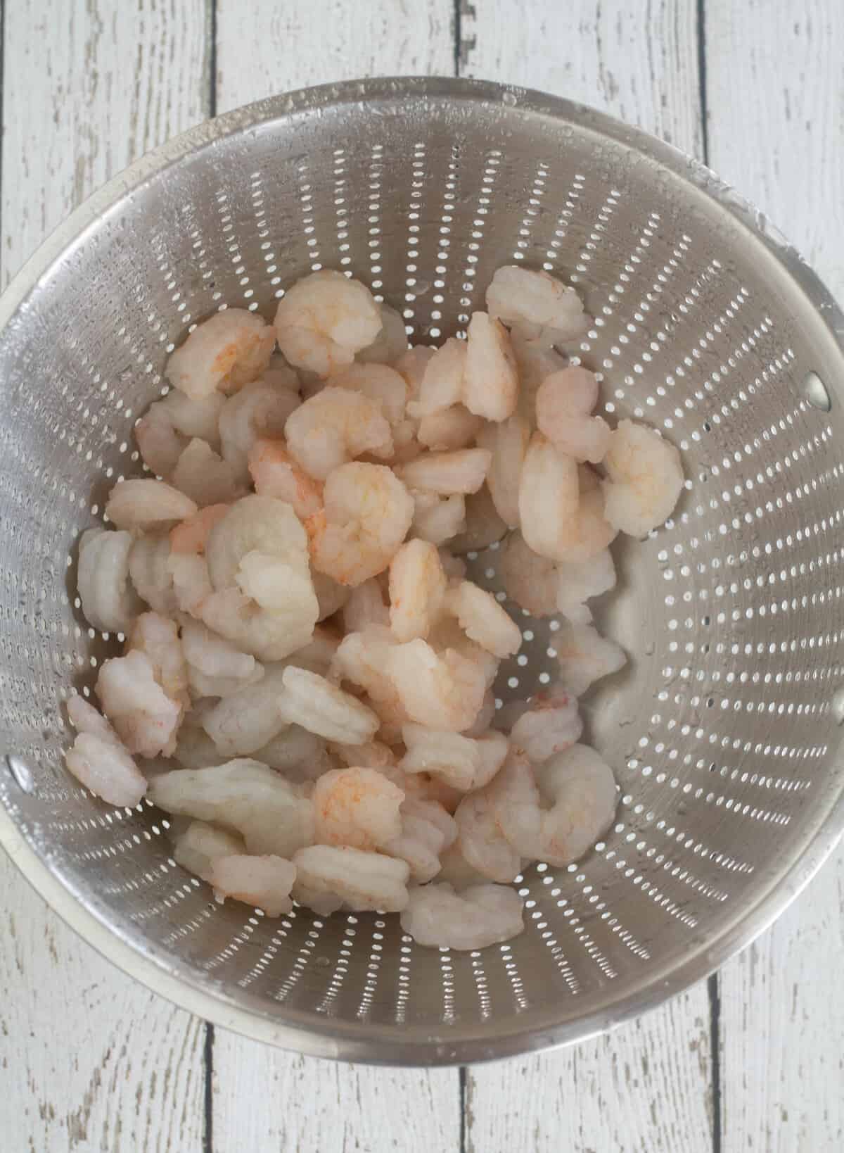 Shrimp thawing in a colander