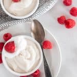 overhead shot of pudding in bowls with raspberries and spoon