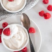 overhead shot of pudding in bowls with raspberries and spoon
