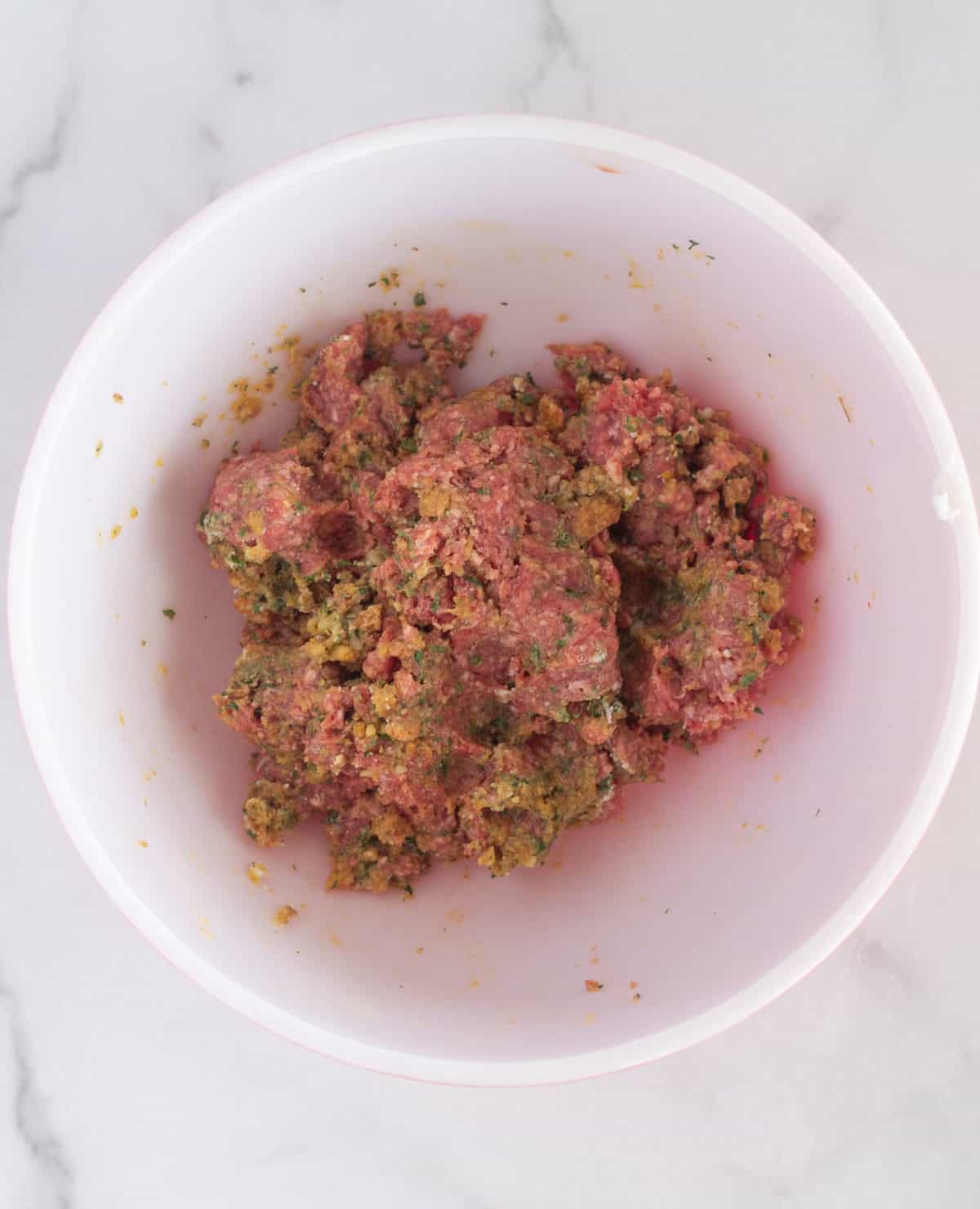 mixed meatball ingredients in mixing bowl