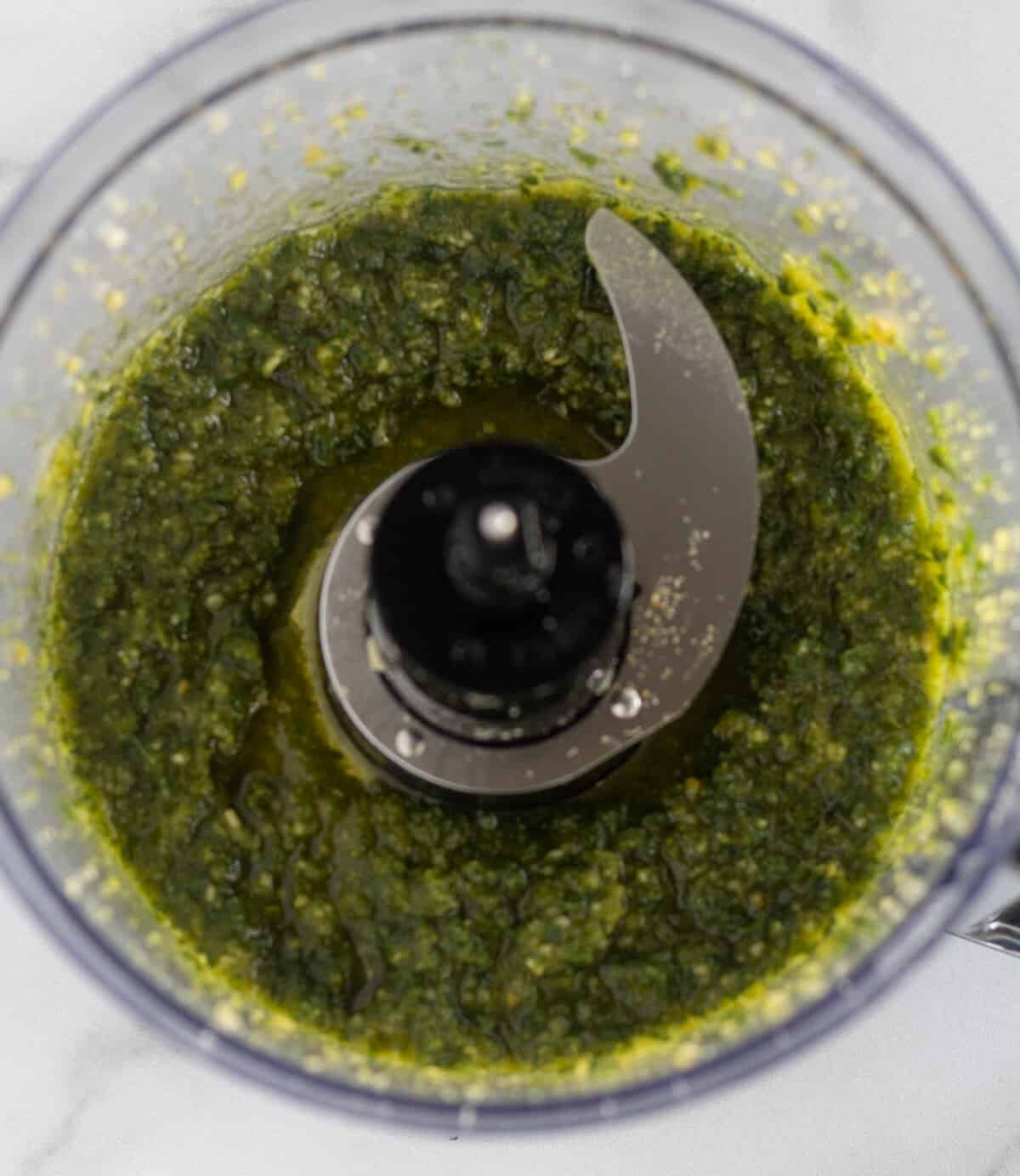 processed pesto in the bowl of a food processor