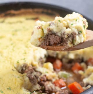 scooping keto shepherd's pie out of a cast iron skillet