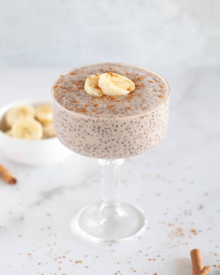 whole30 banana chia pudding in glass dish with sliced bananas.