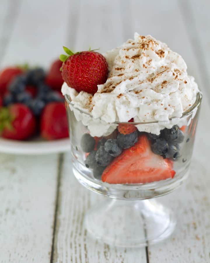 coconut whipped cream in clear serving dish with berries