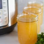 instant pot bone broth in mason jars with an instant pot in the background