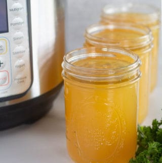 instant pot bone broth in mason jars with an instant pot in the background