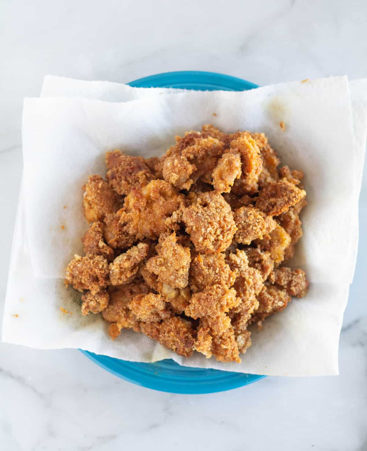 fried chicken pieces on paper-towel-lined plate