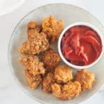 overhead shot of keto chicken nuggets on a plate with ketchup