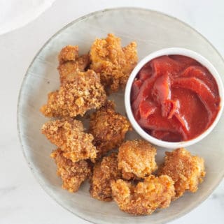 overhead shot of keto chicken nuggets on a plate with ketchup