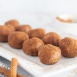 close up of donut holes on white plate