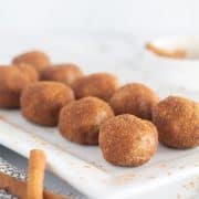 close up of donut holes on white plate