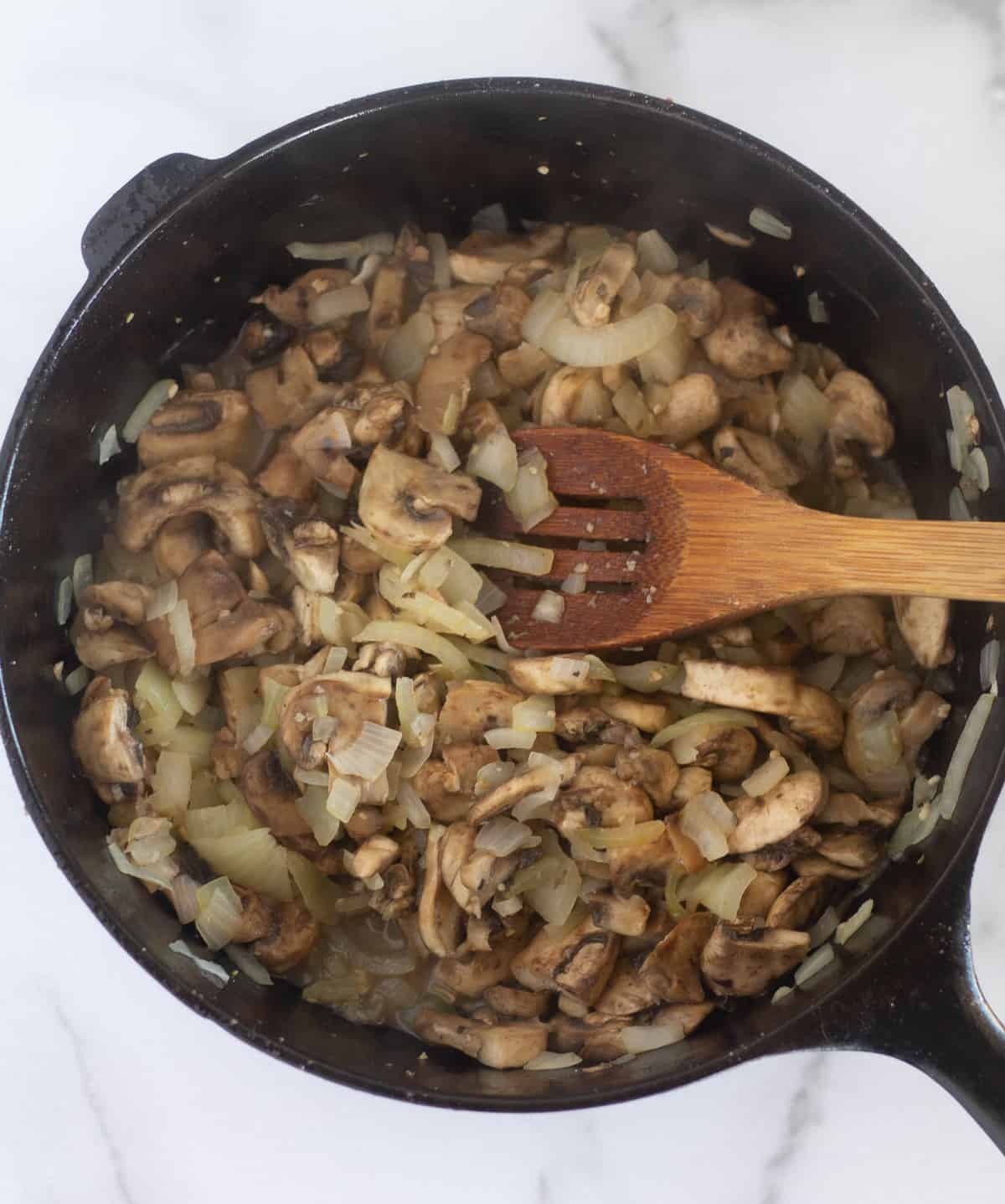 cooked mushrooms and onion in cast iron skillet