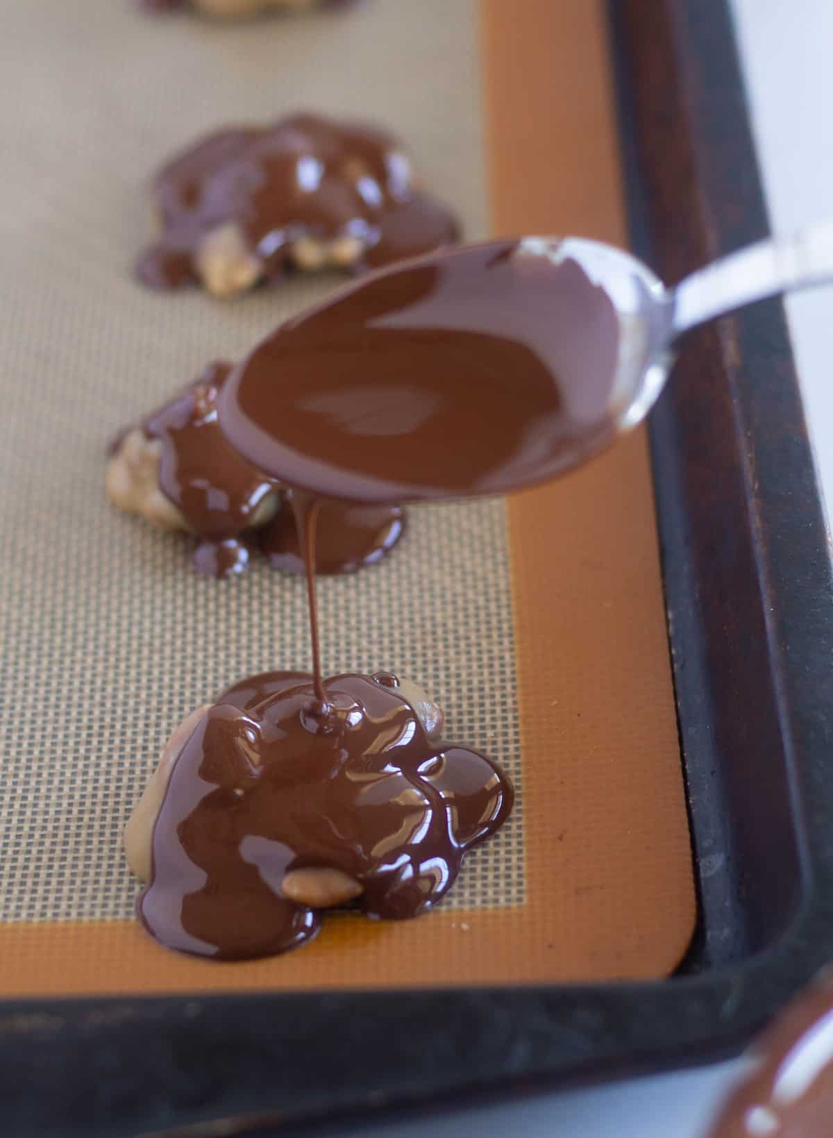 drizzling melted chocolate onto the pecan/caramel mixture