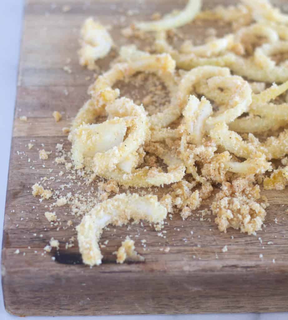 battered onions on a wooden cutting board