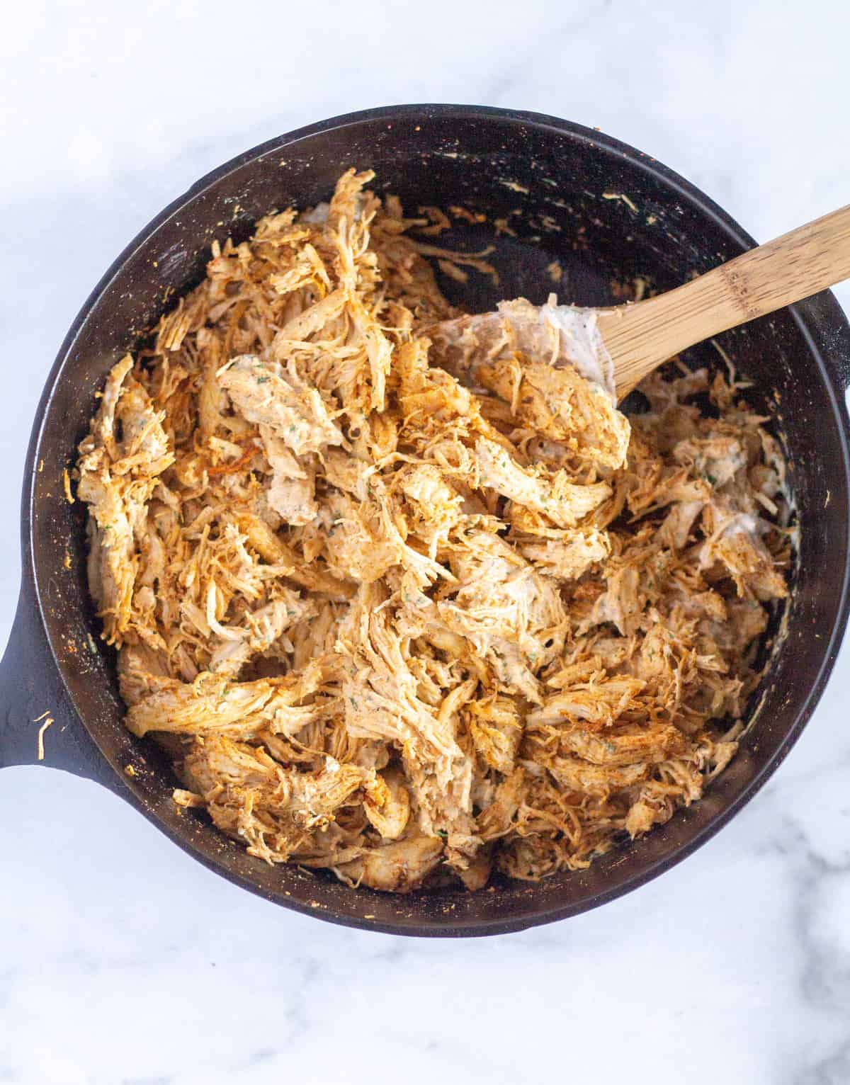 shredded chicken with taco seasoning and ranch in cast iron skillet