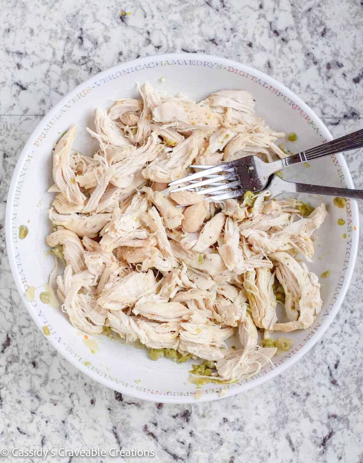 shredded chicken in bowl with 2 forks.
