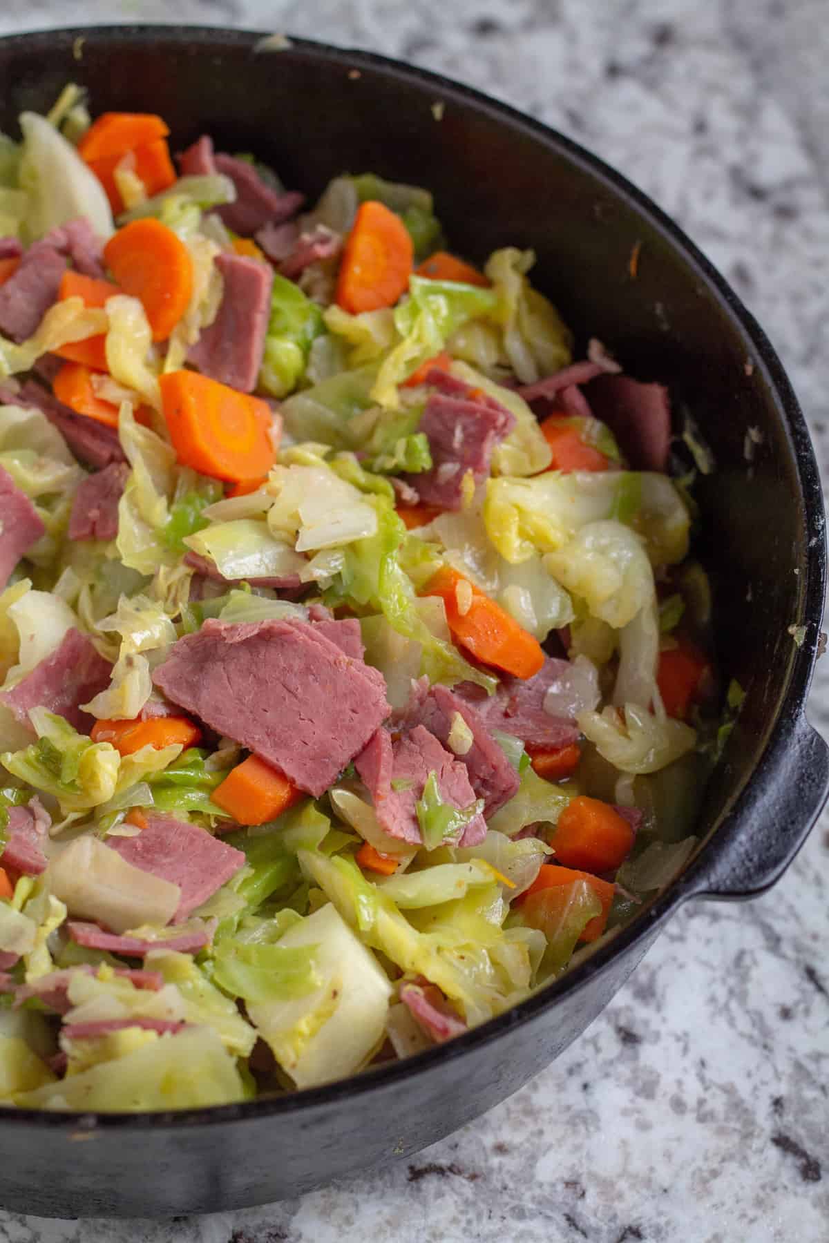 close up of cooked corned beef and cabbage in cast iron skillet