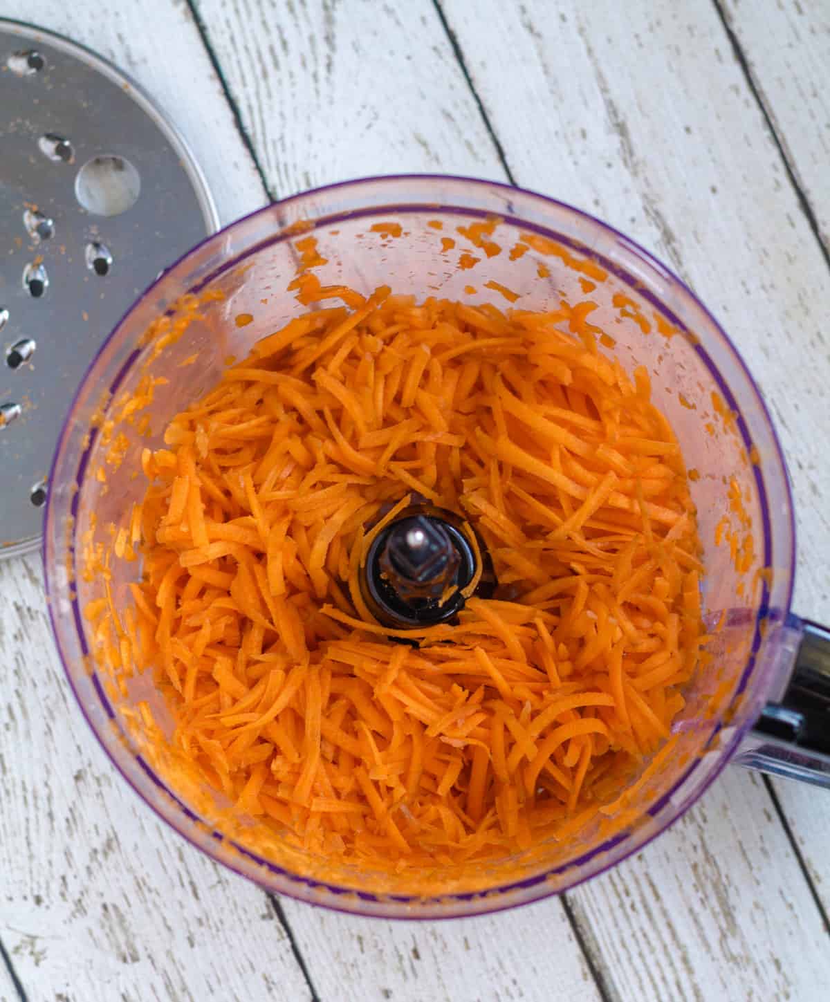 Grated carrots in the bowl of a food processor