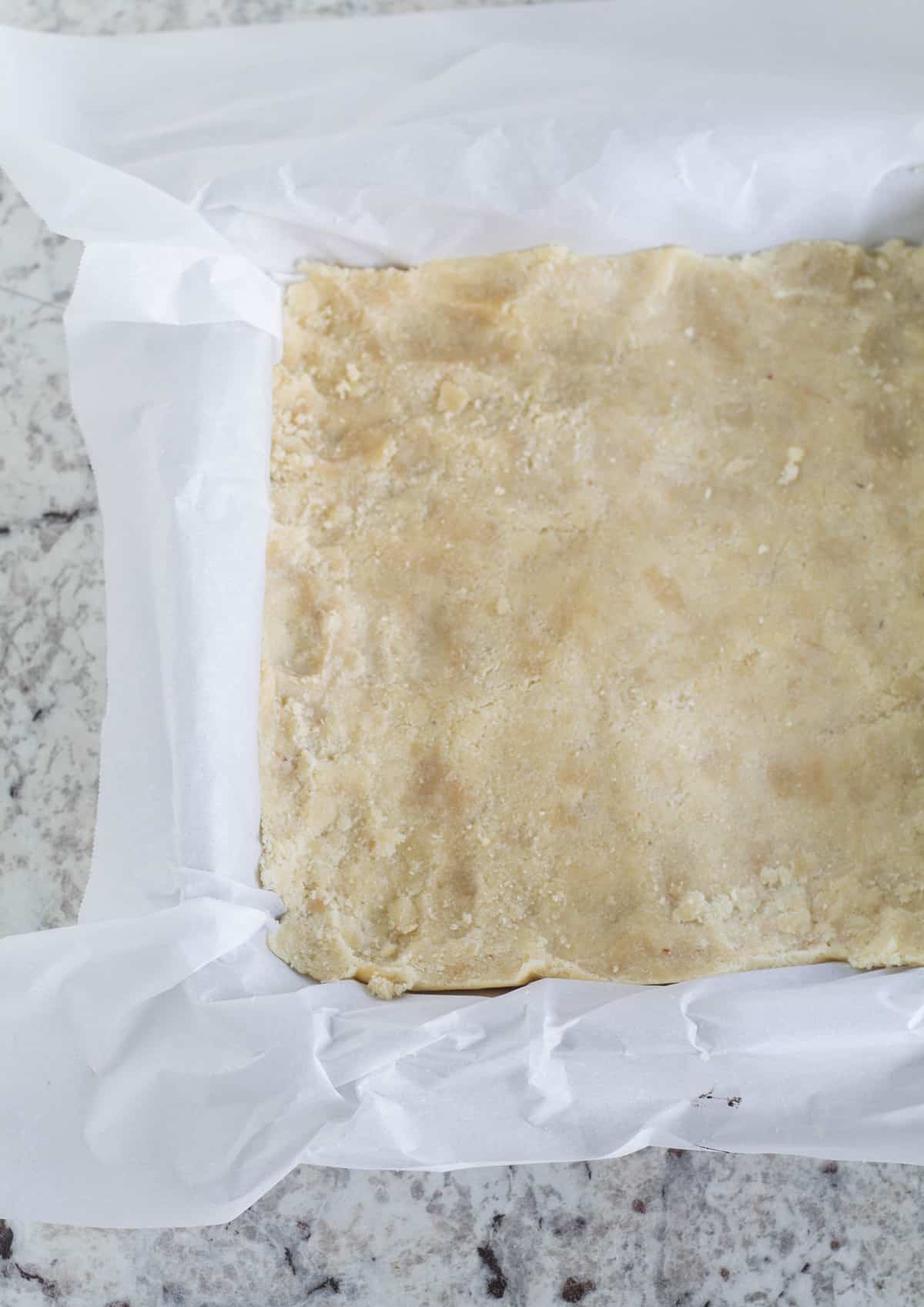 unbaked crust in parchment line baking pan