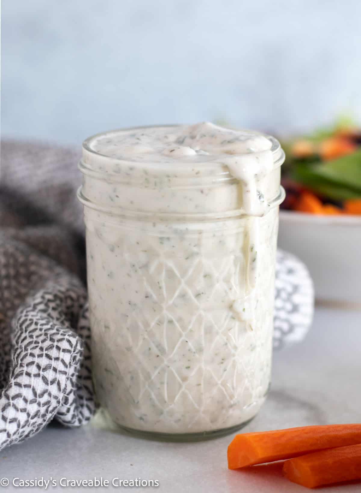 ranch in a mason jar with salad in the background