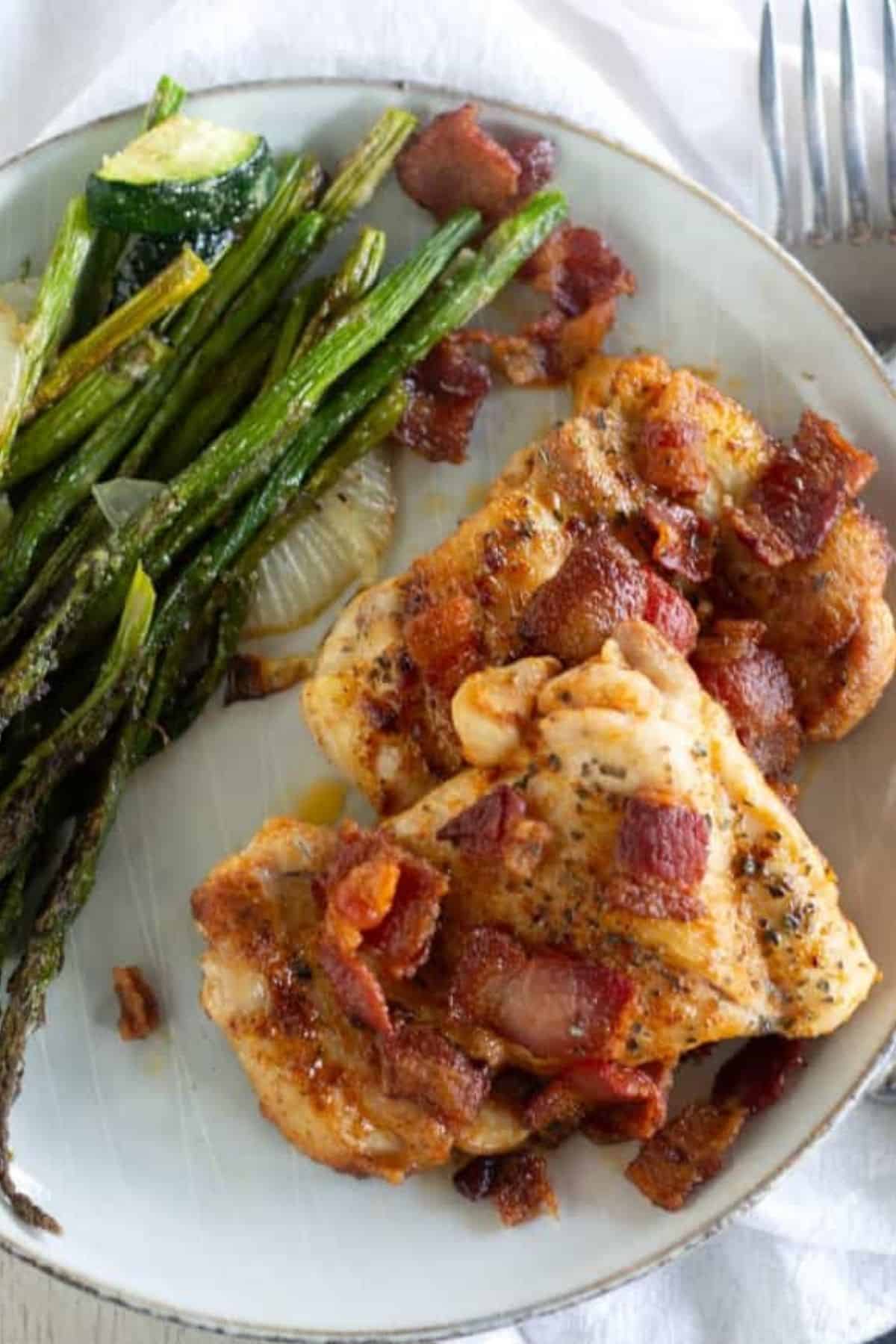 overhead shot of chicken with bacon and asparagus on a plate