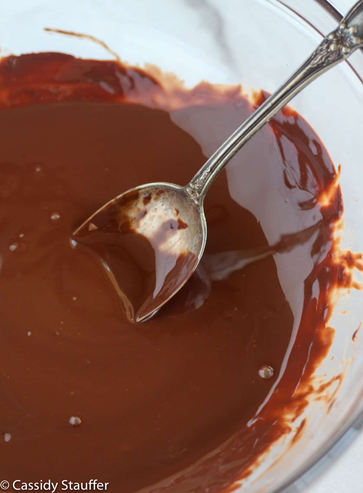 melted chocolate in a bowl with a spoon.