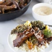 beef and broccoli on plate over cauliflower rice