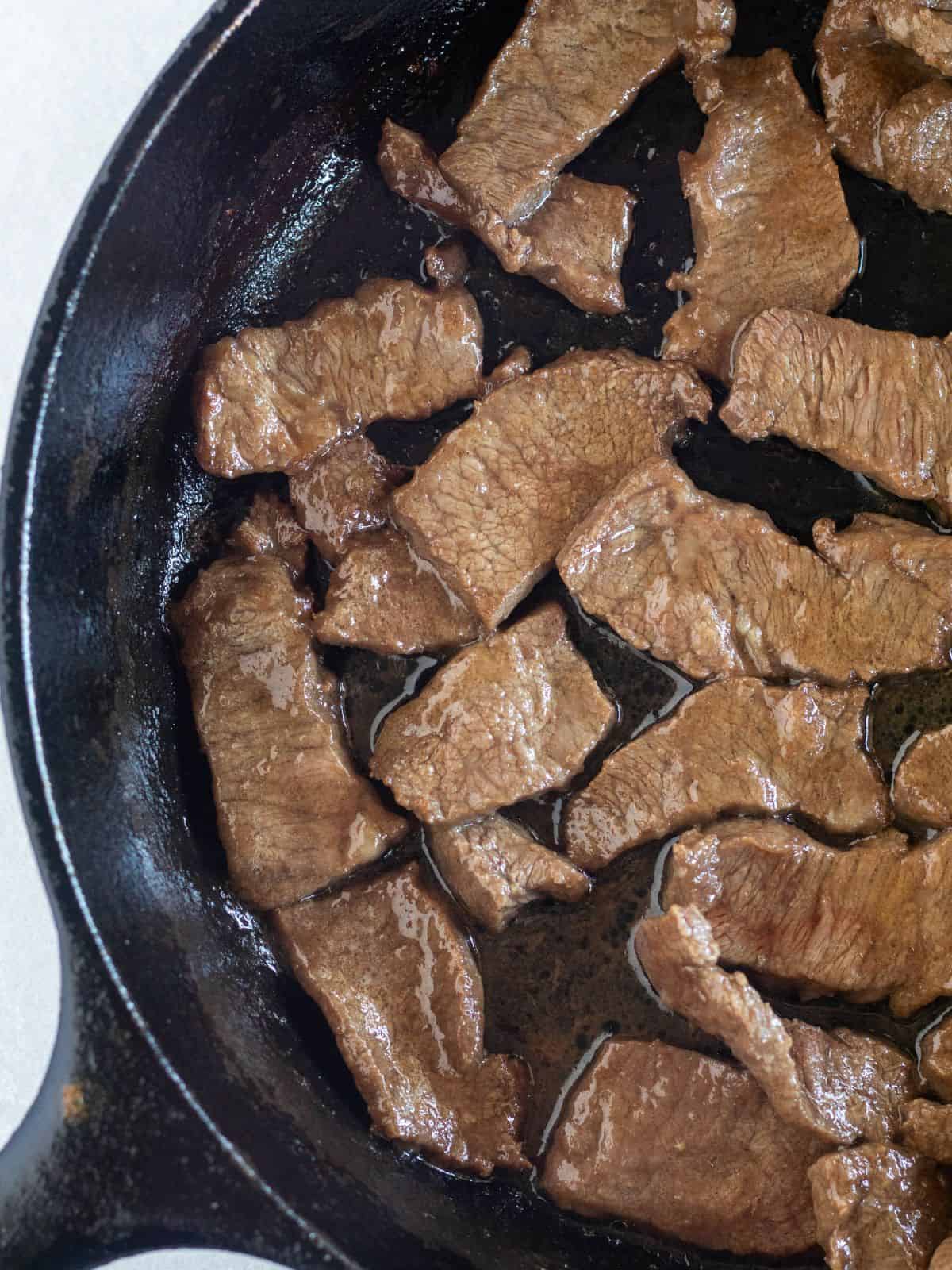 Cooked steak in a cast-iron skillet.