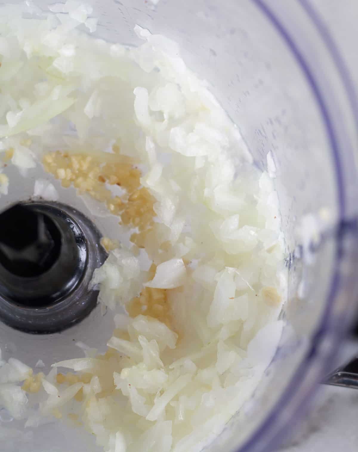 chopped onion, salt, & garlic in bowl of food processor