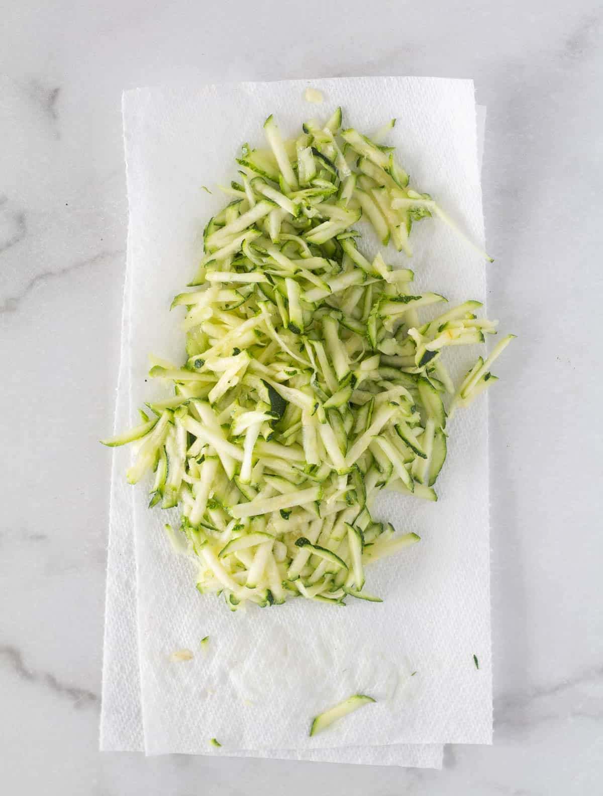 grated zucchini on paper towels.