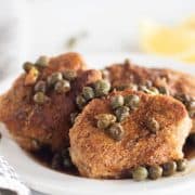 pork tenderloin with capers on white plate