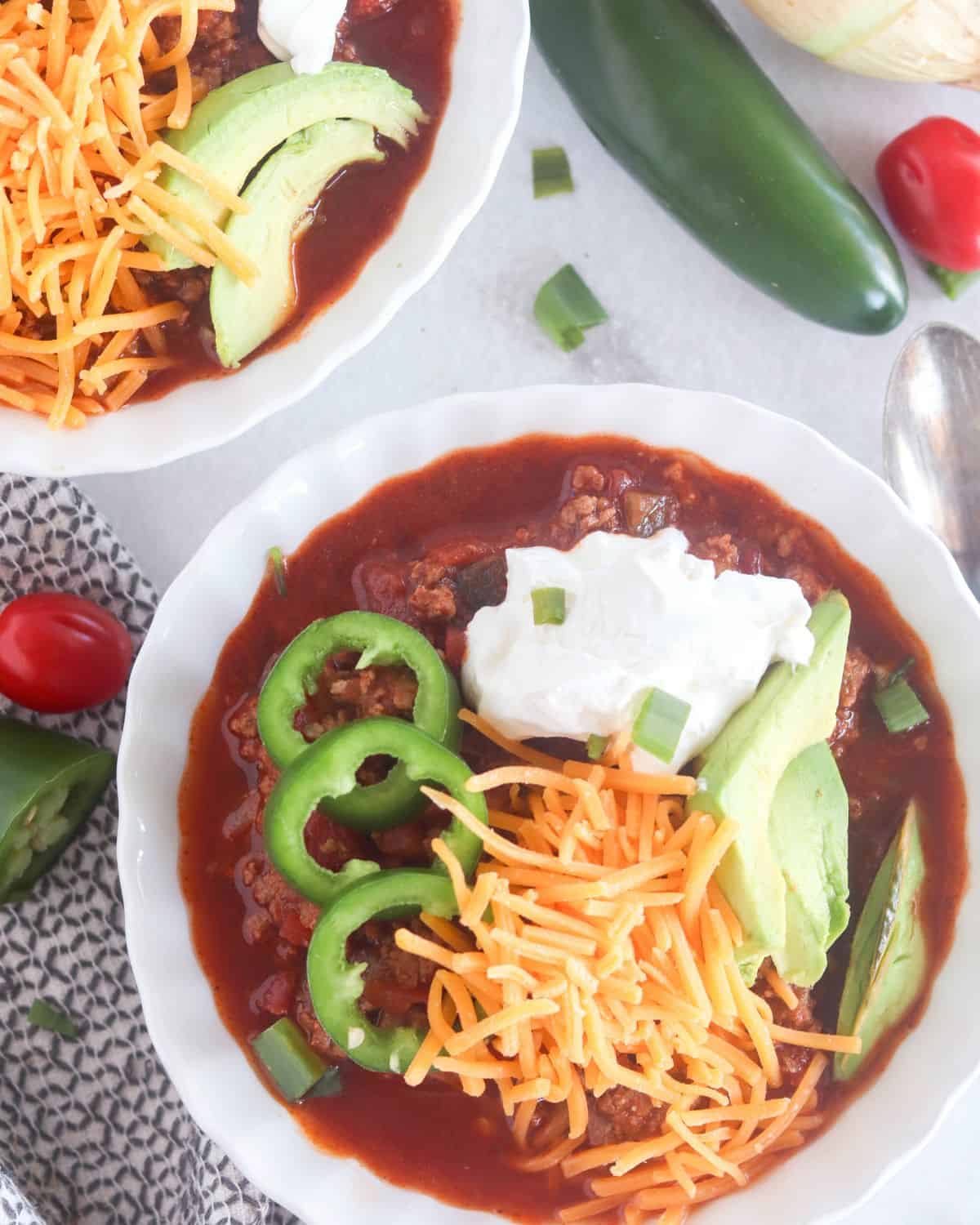 chili in bowls with garnishes.