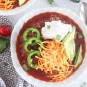 chili in a white bowl with garnishes.