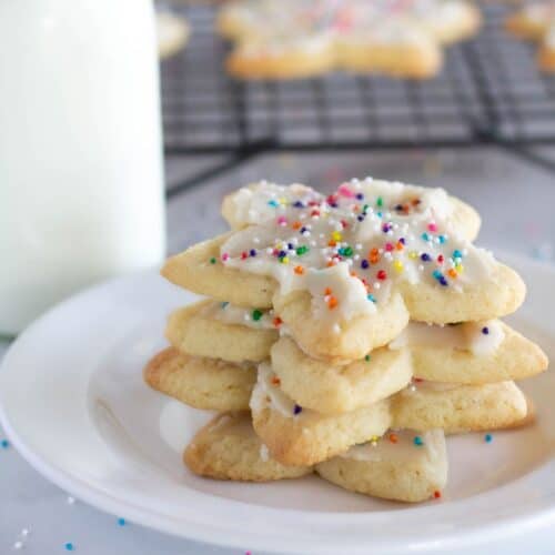square image of keto sugar cookies stacked on a plate.
