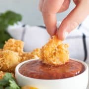 dipping fried shrimp into cocktail sauce