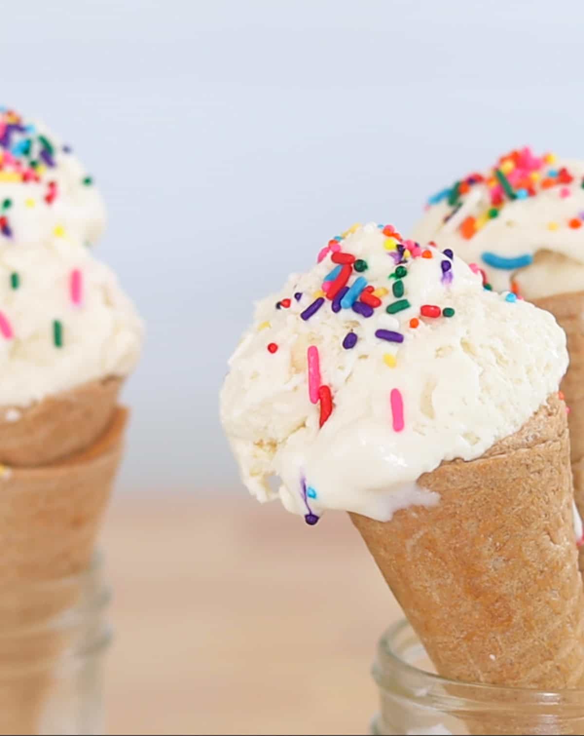 ice cream in cones be held up by mason jars.