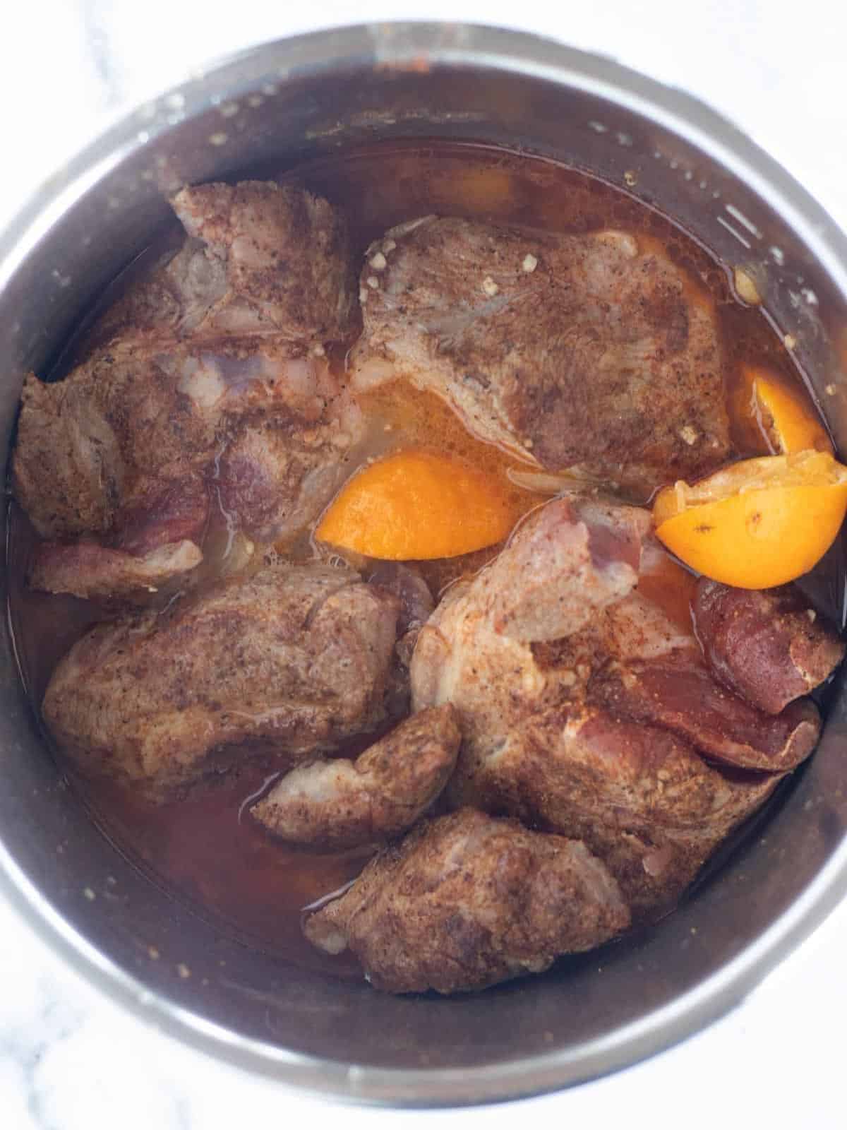 Cooked carnitas in the bowl of an instant pot.