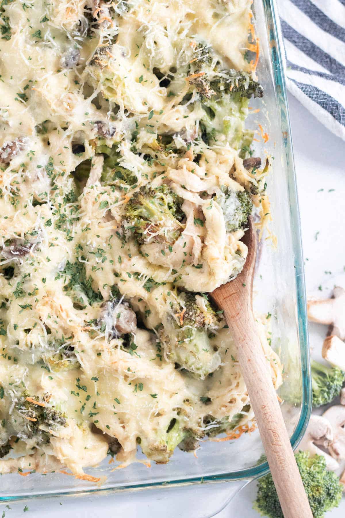 scooping chicken broccoli casserole out of a dish