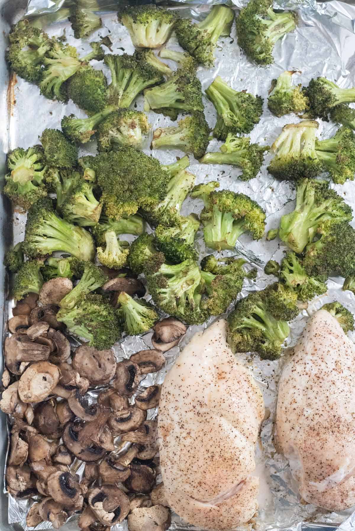 baked chicken, broccoli, and mushrooms on baking sheet