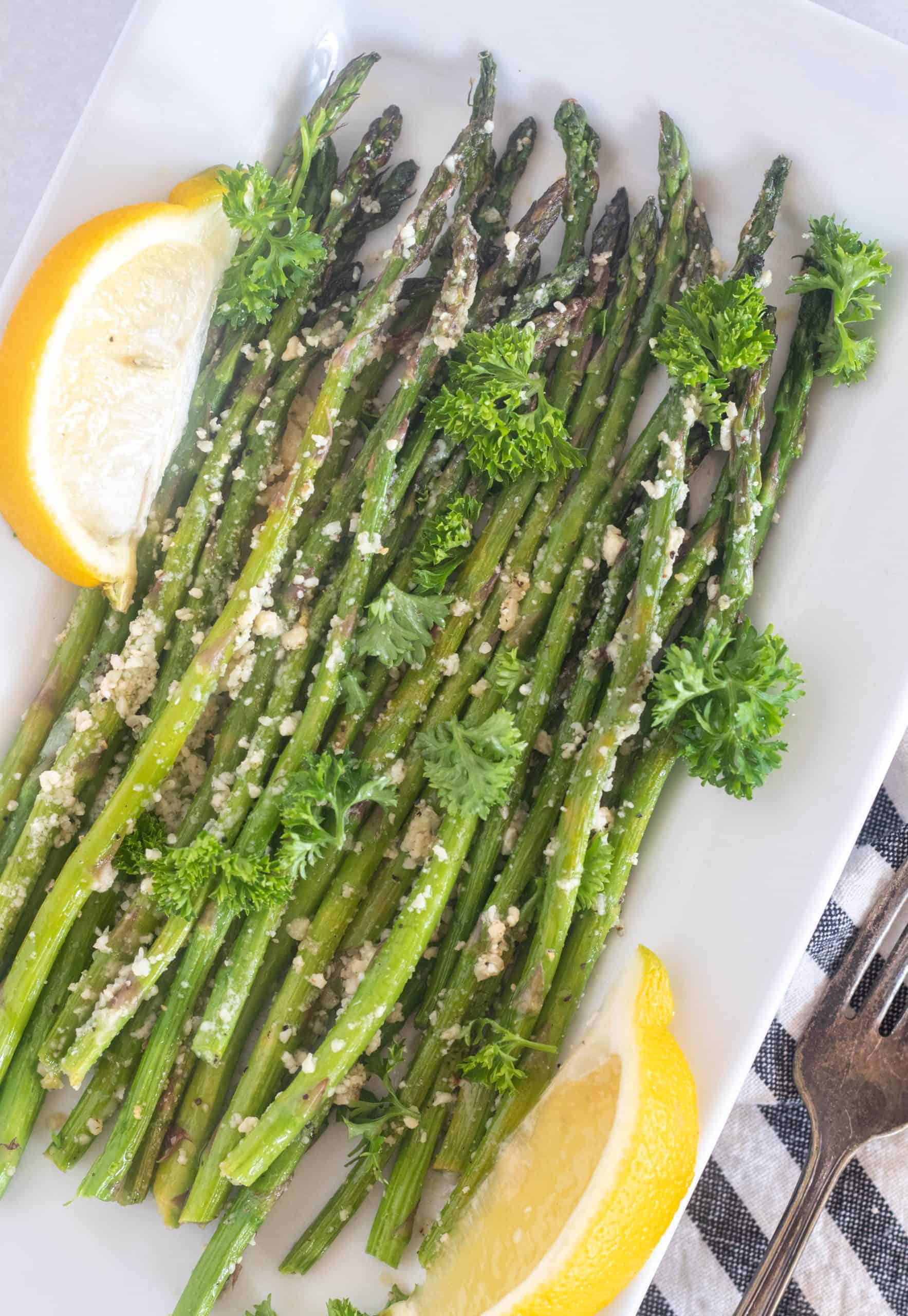 asparagus on a white plate with a lemon slice