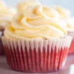 close up of red velvet cupcake with piped cream cheese frosting